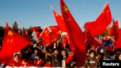 资料照：中国在新西兰的支持者在澳大利亚堪培拉迎接奥运火炬的仪式上挥舞中国国旗。（2008年4月24日）
