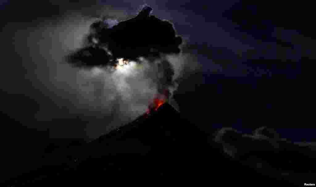 The super blue moon illuminates Mayon Volcano as it spews lava during a mild eruption, hours after a total lunar eclipse in Legazpi, Philippines.