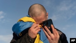 Ілюстративне фото: український військовополонений плаче, телефонуючи своїм родичам після обміну полоненими на українсько-російському кордоні, 31 січня 2024 р. (Фото: AP Photo/Данило Павлов)