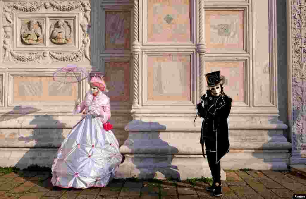 Masked revelers pose during the Venice Carnival in Venice, Italy.
