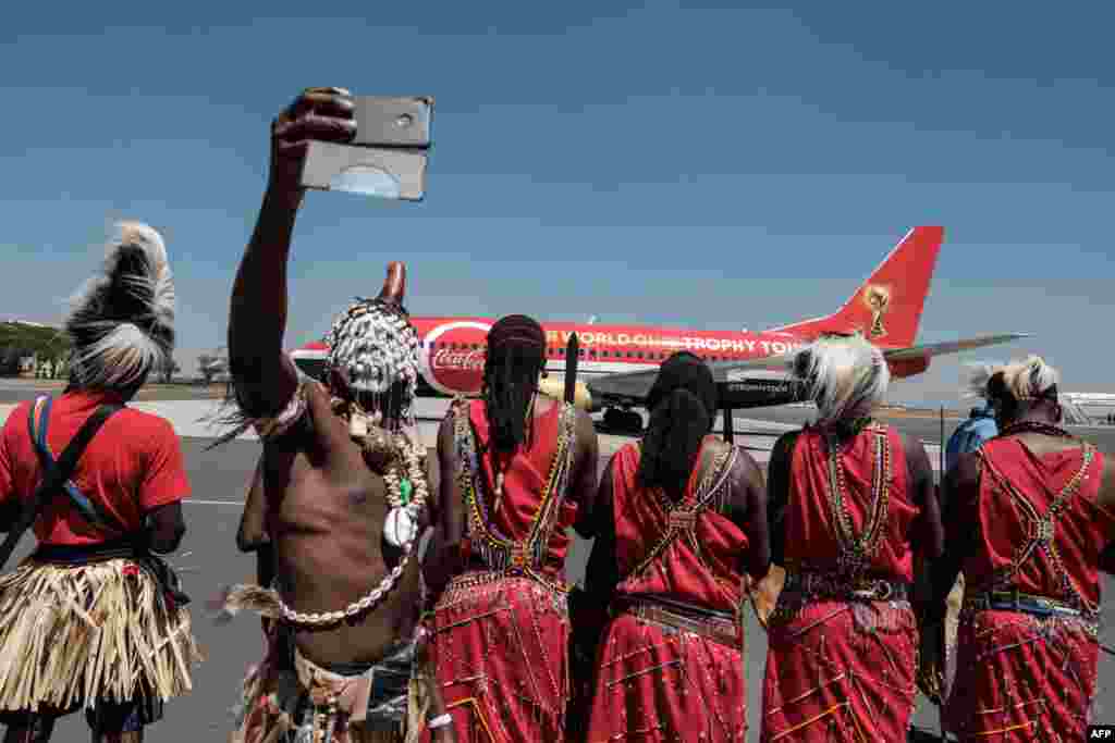 A dancer takes a selfie upon the arrival of the special aircraft carrying the FIFA World Cup Trophy during its World Tour at the Jomo Kenyatta International airport in Nairobi, Kenya.