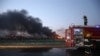 Firefighters work at the site as smoke rises from the debris after the explosions at the Binhai new district in Tianjin, China, Aug. 13, 2015. 