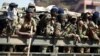 Members of the military gesture to the photographer as they patrol the streets of the capital Harare, Zimbabwe, Aug. 2, 2018. 