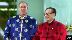 2001年10月21日，时任美国总统布什与时任中国国家主席江泽民身穿丝绸服装出席APEC上海峰会。（美联社）