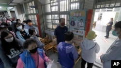 2022年11月26号，居住在台湾新北市的选民在附近的排队投票。参选的民众对将于2024年选出新总统这次投票哪个党派将获得更多支持非常关注。