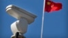 一面中国国旗在监控北京十字路口的海康威视安全摄像头附近飘扬。（2019年10月8日）