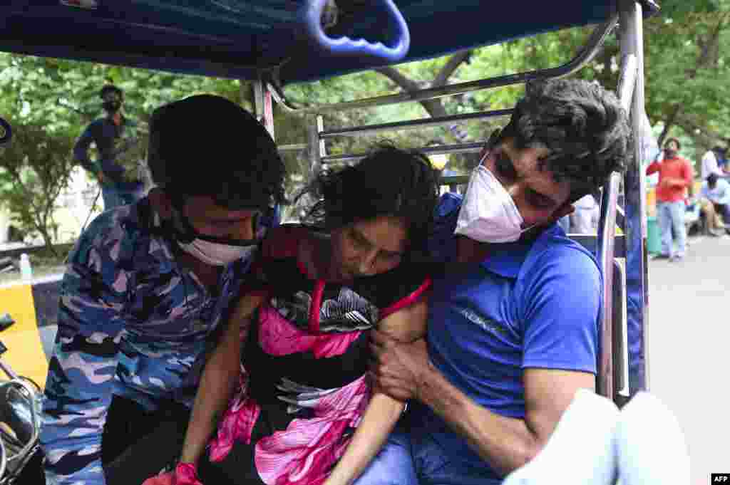 A patient collapses as is rushed on a cycle rickshaw outside a Gurudwara (Sikh Temple) which provides free oxygen to patients amid COVID-19 coronavirus pandemic in Ghaziabad, India.