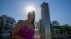 FILE - A woman showers at Sydney's Bondi beach as temperatures in excess of 40 degrees Celsius (104 Fahrenheit) hit parts of eastern Australia on Dec. 9, 2023.
