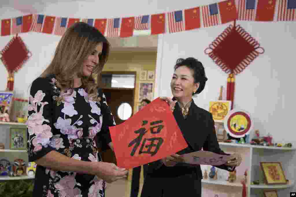 美国第一夫人梅拉尼娅·川普和中国国家主席习近平夫人彭丽媛访问北京板厂小学,两人手持学生写的福字(2017年11月9日)。