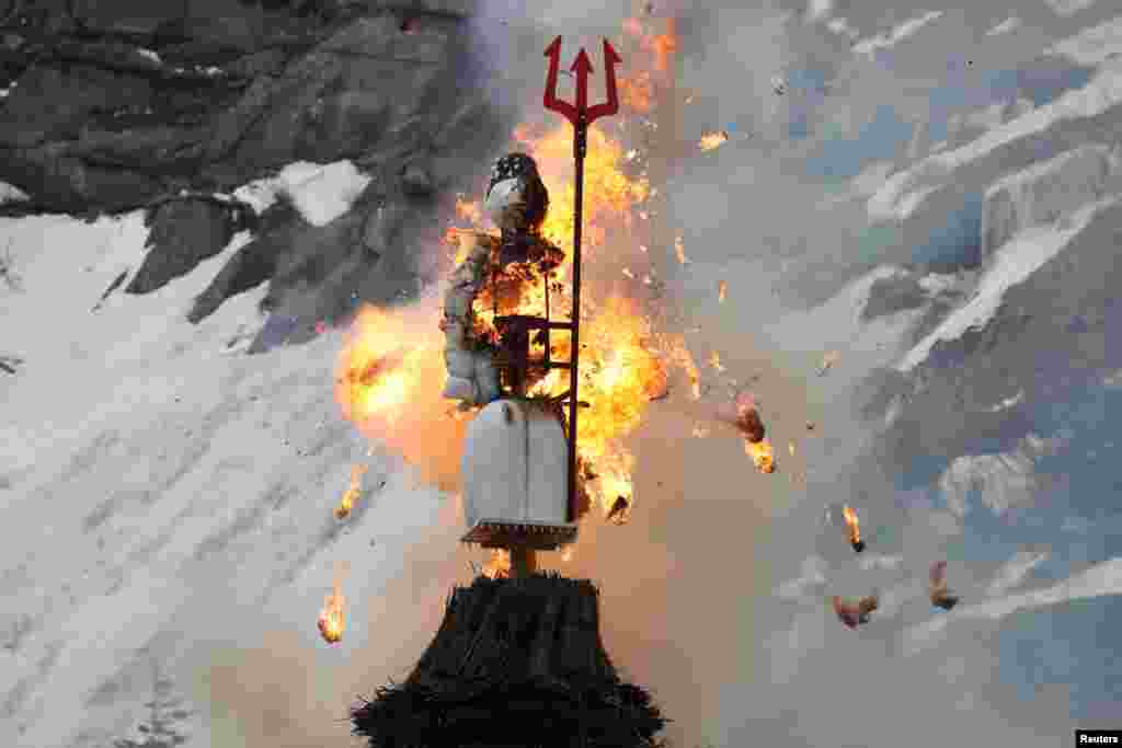 The Boeoegg, a snowman made of wadding and filled with firecrackers, is burning in a bonfire on the landmark of Devil's Bridge in the Schoellenen Gorge near the Alpine resort of Andermatt, Switzerland, April 19, 2021.