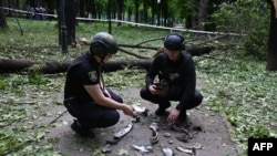 США вказують, що Китай допомагає російському військово-промисловому комплексу. Фото від 19 травня 2024 року: українські поліціянти досліджують фрагменти ракети, після атаки Росії в Харкові.