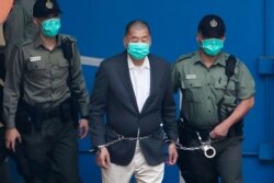 资料照：香港壹传媒集团创办人黎智英在港警看押下走向法庭。（2020年12月12日）