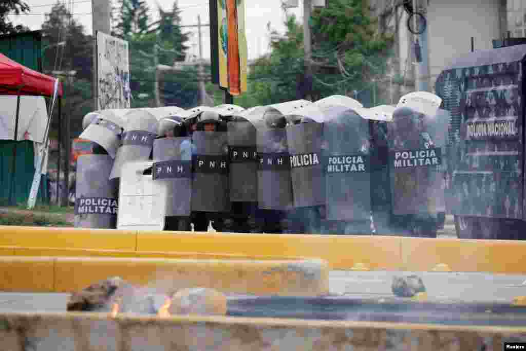 Riot police protect themselves with their shields during a protest against the rise in fuel and energy prices in Tegucigalpa, Honduras, June 2, 2018.