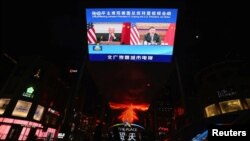 2021年11月16日，北京的户外显示屏上播放中国中央电视台有关国家主席习近平与美国总统拜登视频会议的报道。