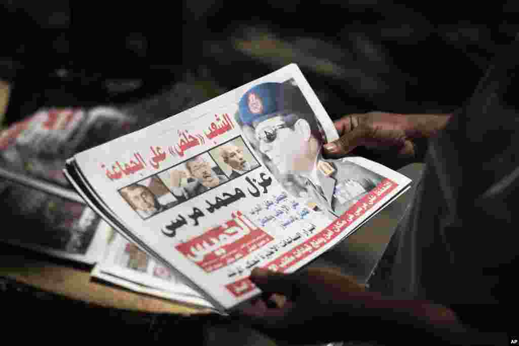 Một người đàn ông Ai Cập cầm một tờ báo gần Quảng trường Mesaha, ở Cairo, 4-7-2013. Chánh thẩm Tòa án Hiến pháp Tối cao Ai Cập tuyên thệ nhậm chức Tổng thống Lâm thời Quốc Gia hôm 4-7-2013.
