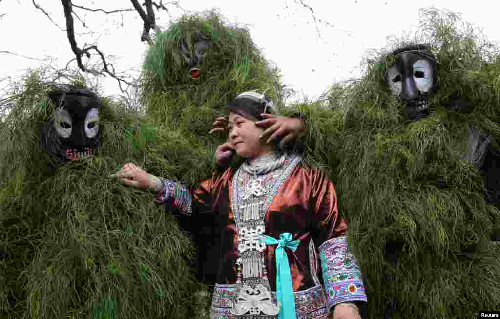 贵州苗族过春节，有人戴面具给妇女脸上抹泥，以祝她好运（2017年2月5日）