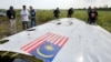 调查人员在乌克兰东部查看MH17航班的一块残骸(2014年资料照)
