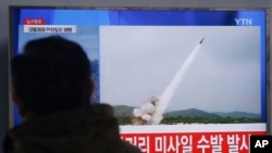 一名韩国男子在首尔火车站观看电视播出的朝鲜发射导弹的资料图像（2016年3月3日）