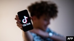 法国西部一名少年在显示有着TikTok标识的手机。（2021年1月21日）