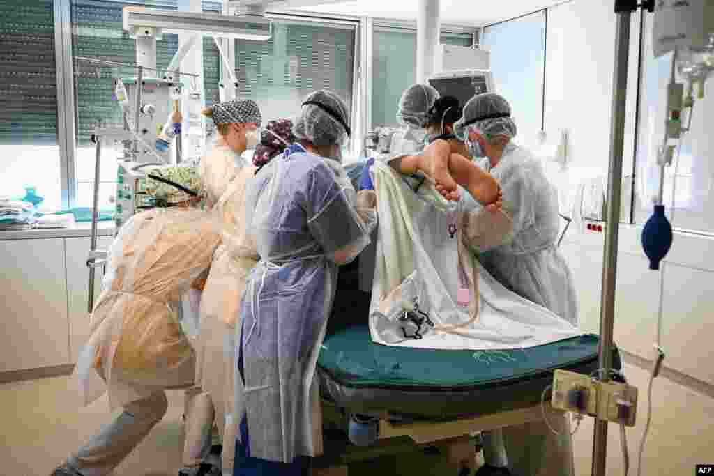 Members of the medical staff hold a patient infected with Covid-19 at the intensive care unit of the Andre-Gregoire intercommunal hospital, in Montreuil, Seine-Saint-Denis, on the outskirts of Paris, France.