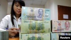 Nhân viên đếm tiền tại quầy của Ngân hàng Quốc tế Việt Nam ở Hà Nội.