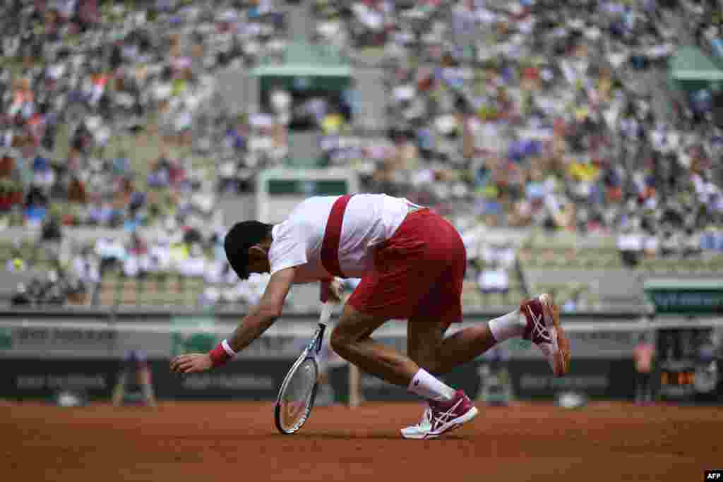 Serbia's Novak Djokovic stumbles during a point against Spain's Jaume Munar during their men's singles second round match on day four of The Roland Garros 2018 French Open tennis tournament in Paris, France.