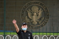 美国驻北京大使馆外的一名中国保安在做手势。（2020年9月12日）