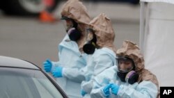 美国科罗拉多国民警卫队医疗人员在丹佛一个“得来速”（drive-through）检疫站为民众做新冠病毒检测。（2020年3月14日）