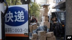 中国“单身节”当天，北京街头快递小哥在分发运送包裹（2019年11月11日）
