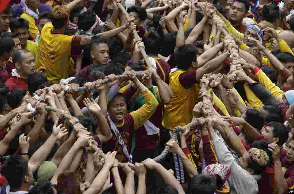 Roman Catholic devotees jostle to grab the rope pulling the carriage of the image of the Black Nazarene during a raucous procession to celebrate its feast day in Manila, Philippines.