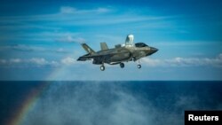 美国海军陆战队一架F-35B战机在南中国海举行的一次飞行行动中正准备在美利坚号两栖攻击舰的甲板上降落。（2020年4月18日）