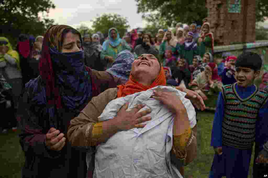 A Kashmiri woman wails holding on to the school shirt of her brother Umar Abdullah Kumar during his funeral procession at Pinjura village 52 kilometers (33 miles) south of Srinagar, Indian-controlled Kashmir. Umar was killed and dozens others wounded after Indian troops fired at rock-throwing protesters who helped the trapped rebels escape.