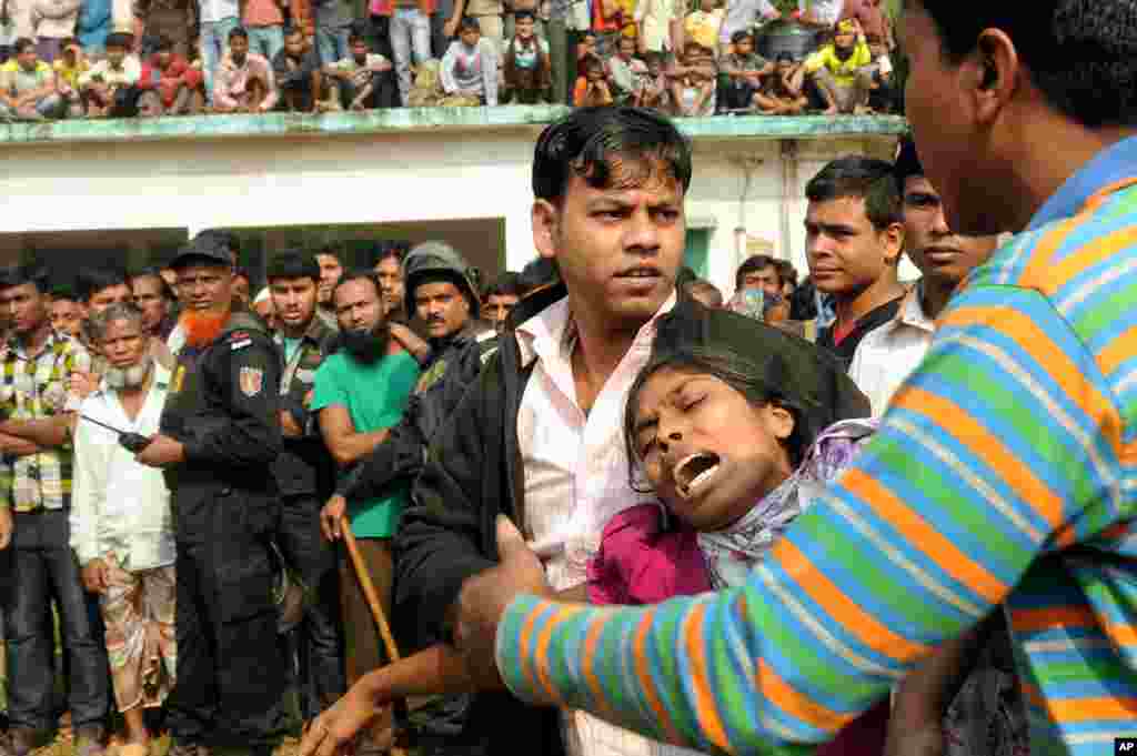 Dân chúng Bangladesh an ủi một phụ nữ bị mất người thân trong vụ hỏa hoạn nhà máy dệt may bên ngoài thủ đô Dhaka, ngày 25/11/2012. 