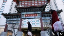 资料照片：居民从北京王府半岛酒店门前经过。(2018年11月16日)