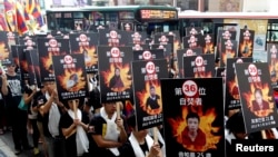 活动人士手举自焚藏人的相片在台北举行支持藏人的游行集会（2013年3月10日）