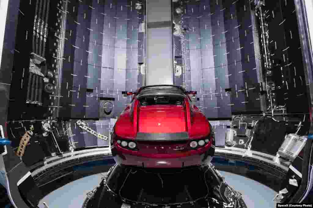 SpaceX公司提供的2017年12月6日的照片显示,在美国佛罗里达州卡纳维拉尔角,一架猎鹰重型火箭的整流罩旁边有一辆特斯拉汽车。猎鹰重型火箭的首次飞行,携带航天器和特斯拉的跑车。