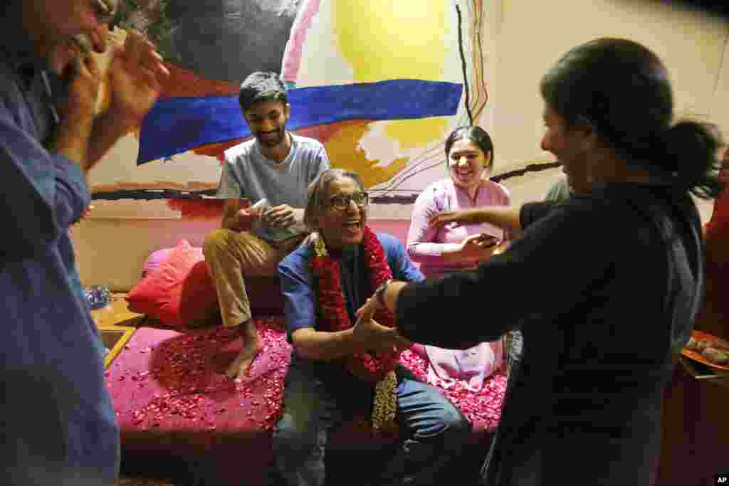 India's Balkrishna Doshi, center in blue, who won the 2018 Pritzker Architecture Prize, celebrates the announcement with his family members at his home in Ahmadabad. He is the first from India to win architecture's highest honor in the prize's 40-year history.