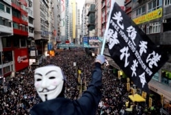 资料照：香港民众打着“光复香港、时代革命”的旗帜参与反政府示威（路透社2019年12月8日）