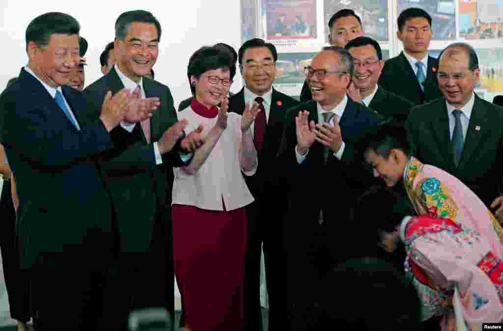 中国领导人习近平在香港特首梁振英和当选特首林郑月娥陪同下参观了新建的西九文化区,观看了儿童粤剧表演,为演员鼓掌。(2017年6月29日)