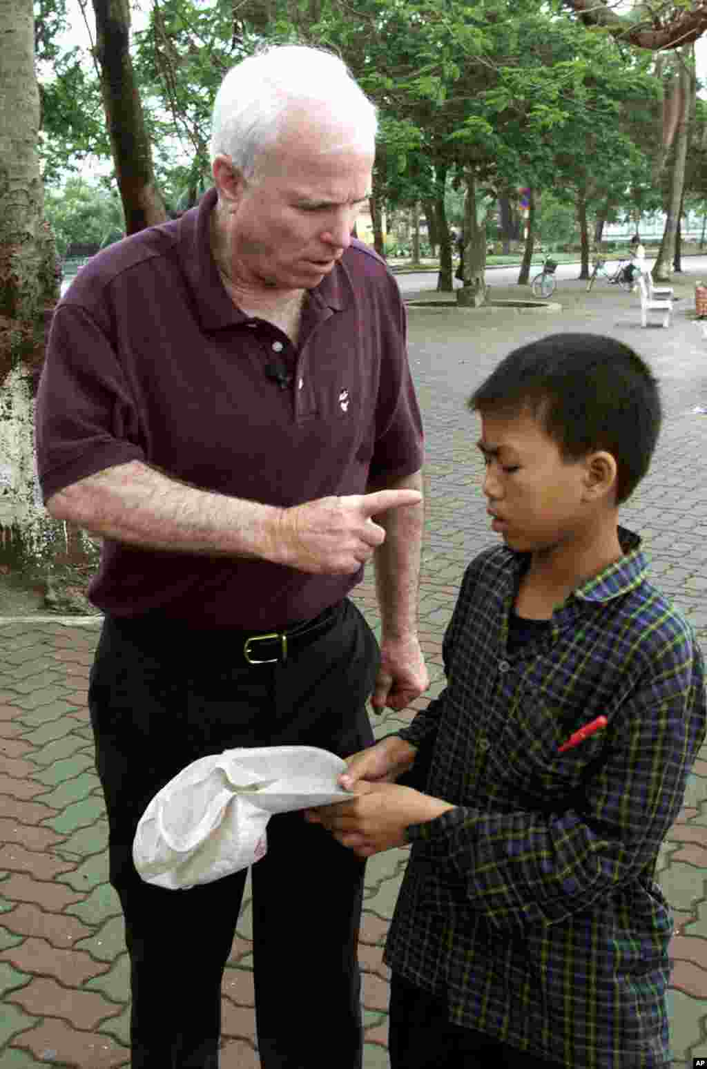 Ông McCain la mắng một cậu bé xin tiền bên bờ Hồ Trúc Bạch ở Hà Nội, ngày 27 tháng 4 năm 2000. Theo tường thuật của AP, trước đó ông đã cho tiền nhưng rồi ông nổi nóng và đuổi đi chỗ khác sau khi cậu bé tới hỏi xin lần nữa. 