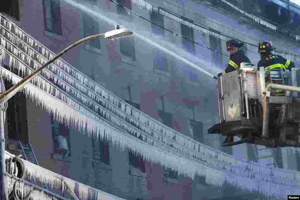 Fire Department of New York (FDNY) firemen put out fire at an apartment building in the Bronx, New York.