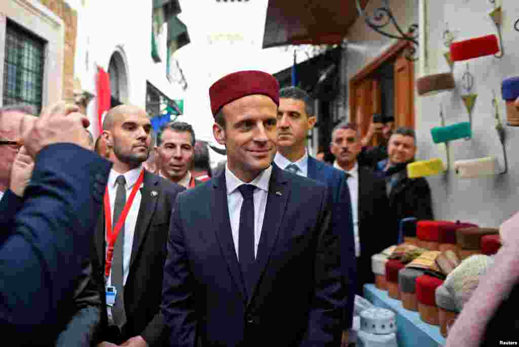 French President Emmanuel Macron wears a fez during his tour of the Medina (old town) of the Tunisian capital Tunis.