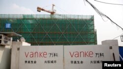 上海一栋建筑工地门口悬挂着万科标志。万科总裁传被公安带走的消息传出后，星期五股价暴跌逾8%。(路透社：2017年3月21日)