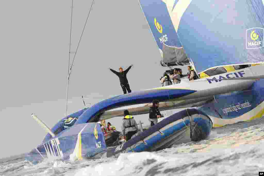 French skipper, Francois Gabart, waves aboard his 30m MACIF trimaran as he celebrates his world record off Brest harbor, western France. Gabart has broken the record for sailing around the world alone, circumnavigating the planet in just 42 days and 16 hours.