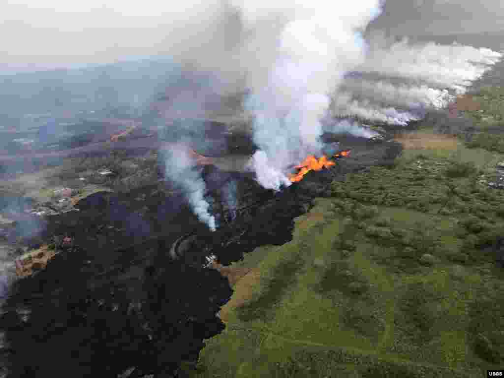 Aerial view of erupting fissure 22 and lava channels flowing southward from the fissure during an early morning overflight during ongoing eruptions of the Kilauea Volcano in Hawaii, May 21, 2018. (Photo courtesy of Volcano Helicopters)