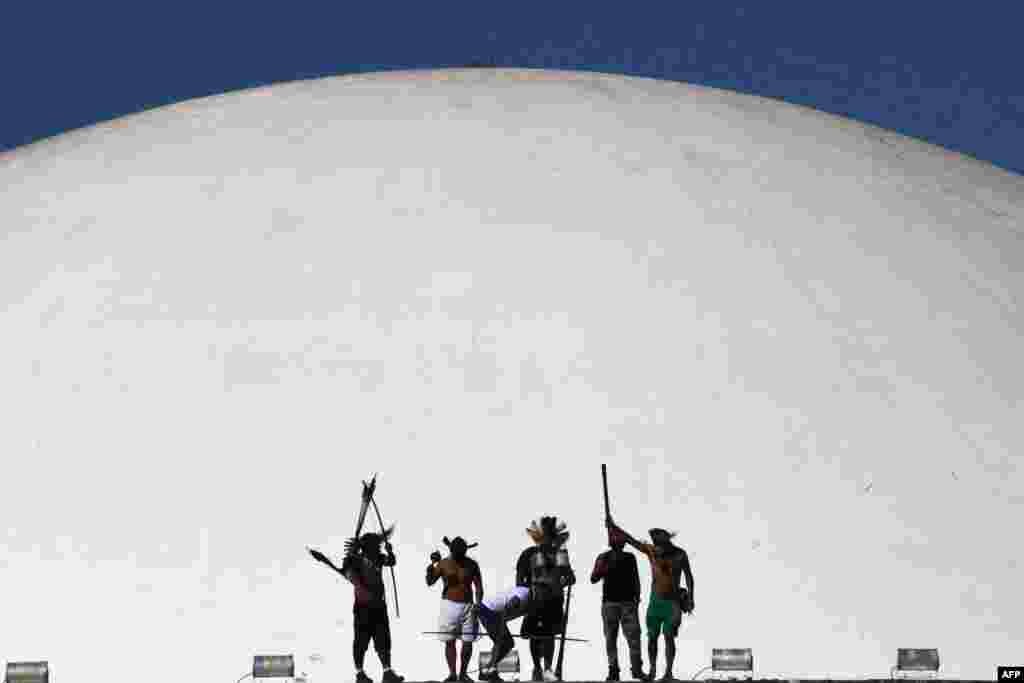 Brazilian Indigenous from different tribes protest against a bill that is being discussed in the Deputies Chamber that changes the rules of the indigenous territories demarcation, at the top of of the National Congress building in Brasilia, on June 8, 2021.