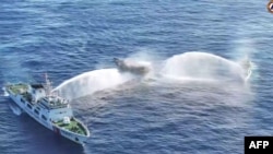 Picha ya Jumanne ya meli za China zikirusha maji kwenye meli ya Ifilipino iliopo kati kati, kwenye maji ya bahari ya South China Sea