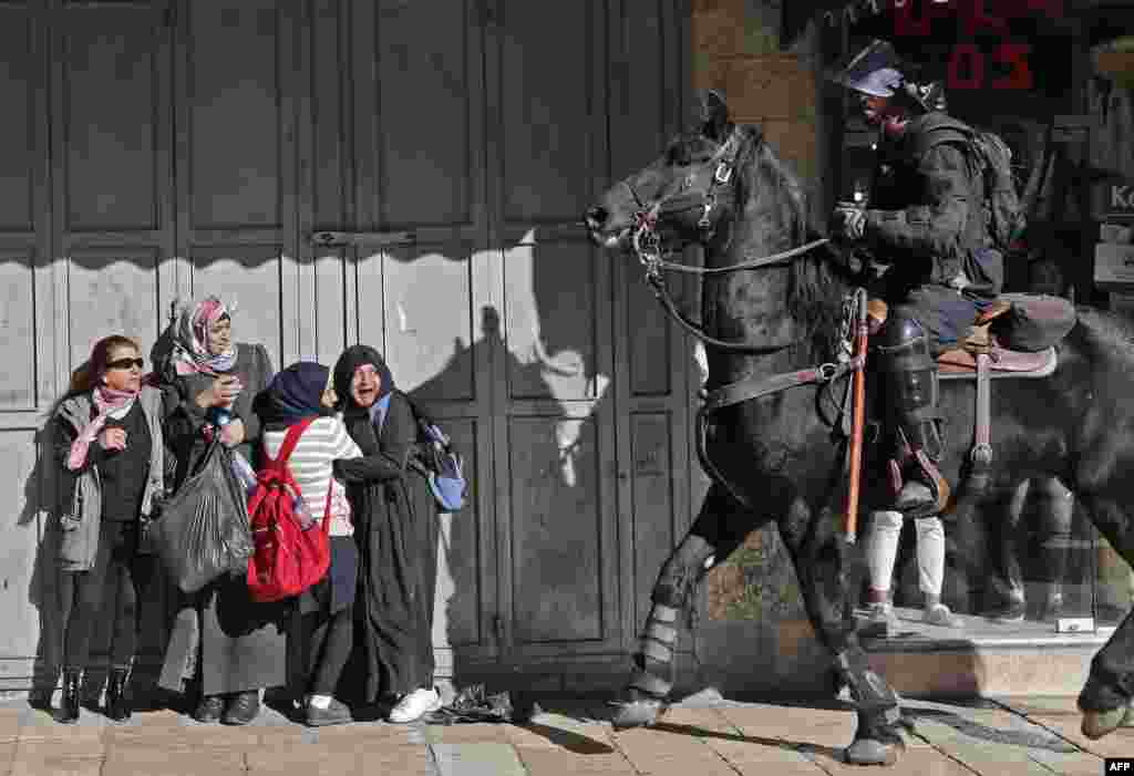 Women react as an Israeli mounted policeman disperses Palestinian protesters in East Jerusalem, Dec. 9, 2017.