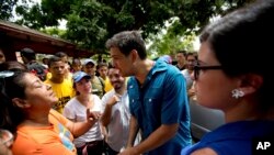 Опозиційний кандидат Карлос Окарис, який балотується на позицію губернатора штату Міранда, розмовляє з жінкою в Гуаренасі.