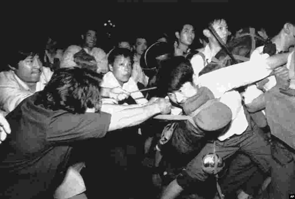 一名男子试图将一个中国士兵拉出队伍。数千名北京市民把正在赶往天安门广场的数千名士兵拦截在路上(1989年6月3日)